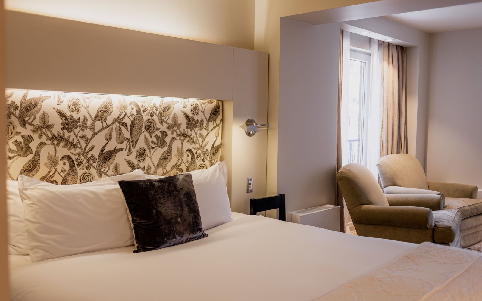 A Bedroom With A Bed And Chairs